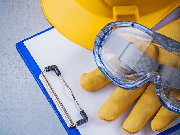 protective-glasses-gloves-notepad-hard-hat-metallic-backgroun